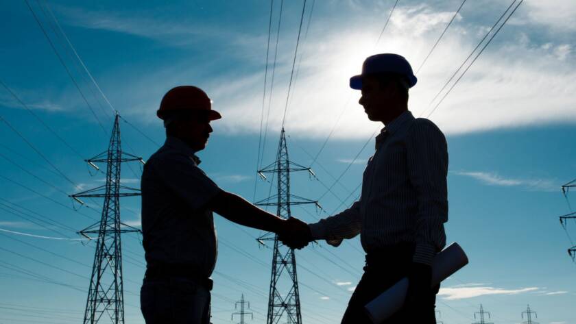 Two electricians shaking hands to start a project.