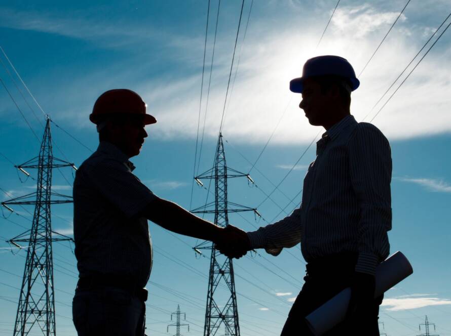 Two electricians shaking hands to start a project.